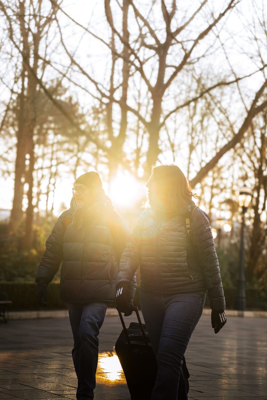 Participants au coucher du soleil, valise à la main